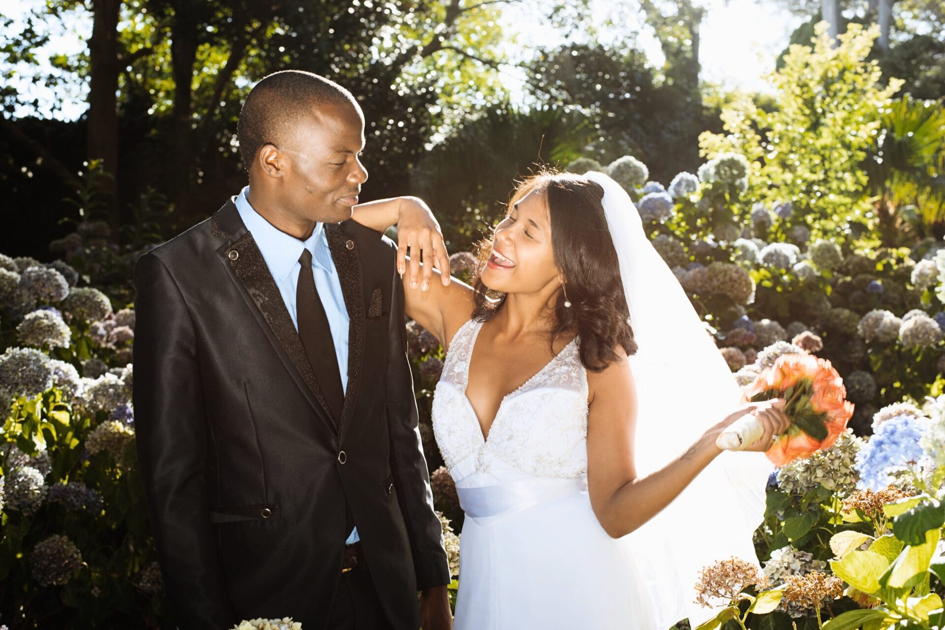 Joyful couple on their wedding day in a sunlit garden